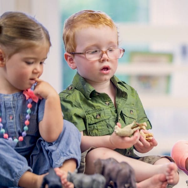 a group of young children sitting next to a child